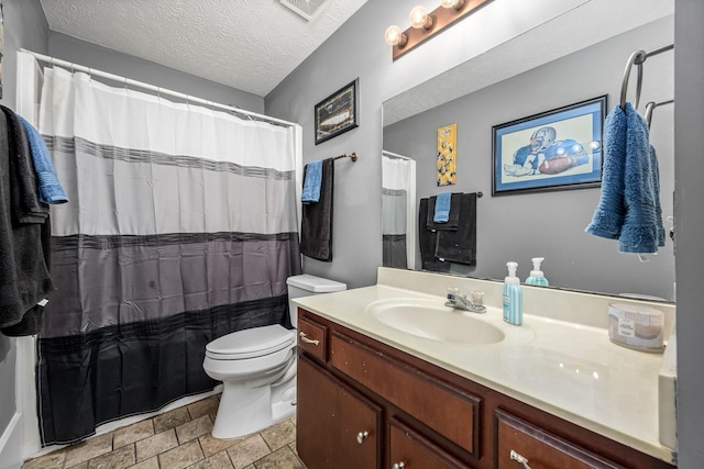 bathroom featuring vanity, toilet, and a textured ceiling