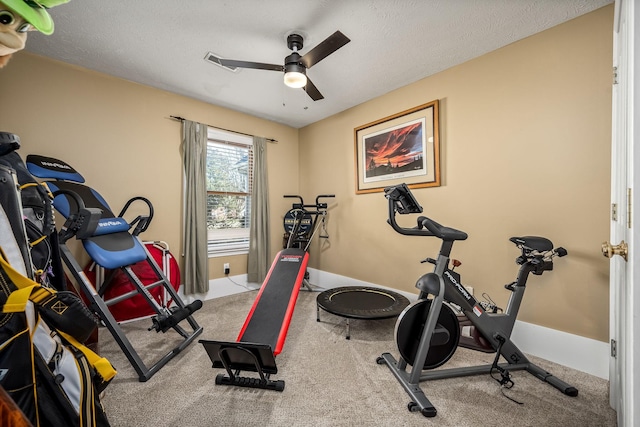 workout area featuring ceiling fan and a textured ceiling