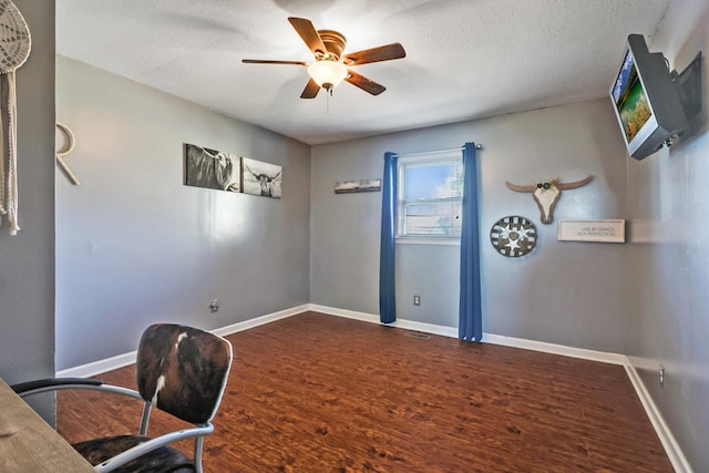 home office featuring ceiling fan, dark hardwood / wood-style flooring, and a textured ceiling