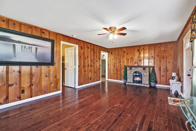 unfurnished living room featuring a fireplace, dark hardwood / wood-style flooring, and ceiling fan