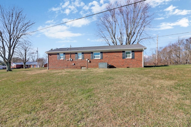 rear view of property with a lawn and cooling unit