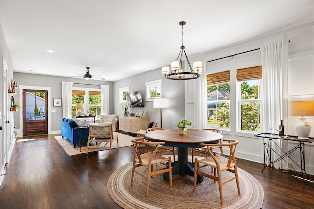 dining room featuring dark hardwood / wood-style flooring and ceiling fan with notable chandelier