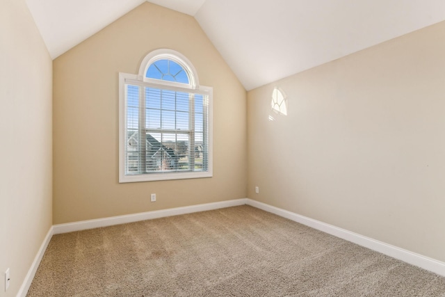 carpeted spare room with lofted ceiling