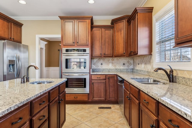 kitchen featuring sink, ornamental molding, stainless steel appliances, and light stone countertops