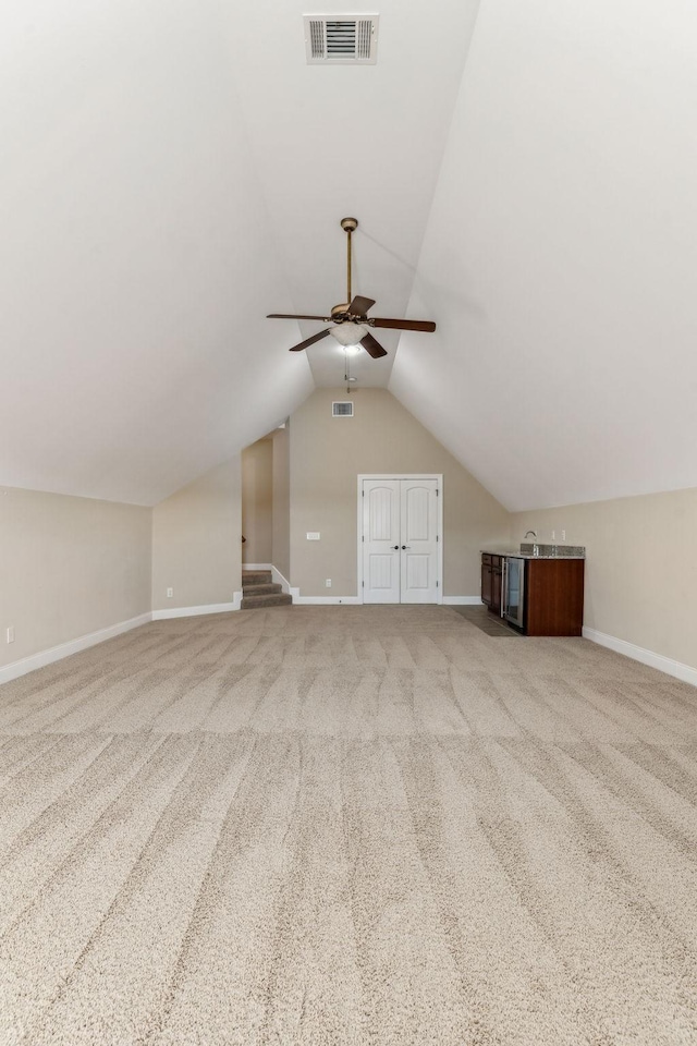 additional living space with ceiling fan, vaulted ceiling, and light carpet