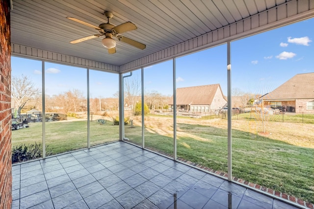 unfurnished sunroom with ceiling fan