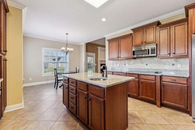 kitchen featuring sink, stainless steel appliances, tasteful backsplash, a center island with sink, and a chandelier