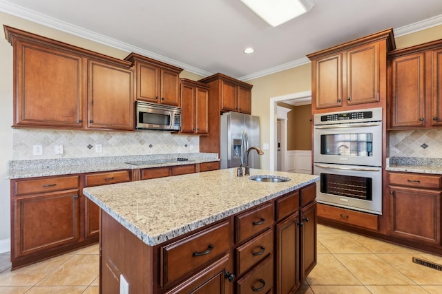 kitchen with sink, light tile patterned floors, a kitchen island with sink, stainless steel appliances, and ornamental molding