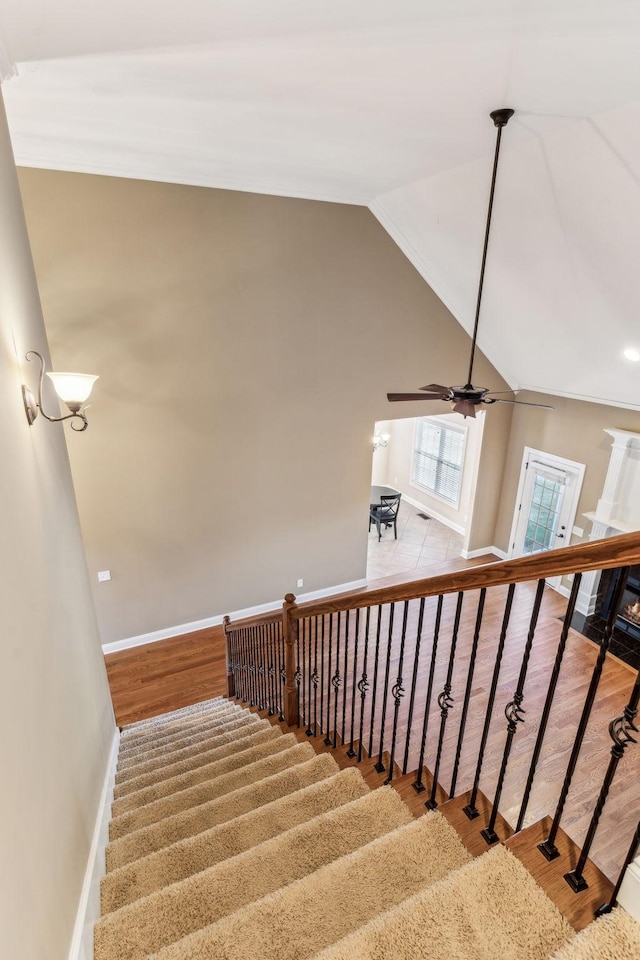 staircase featuring lofted ceiling, hardwood / wood-style floors, and ceiling fan