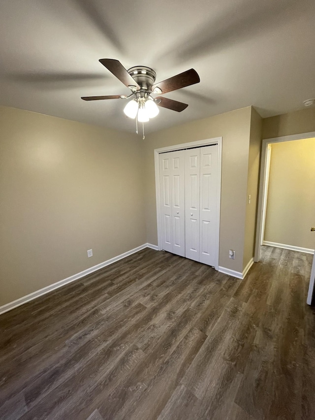 unfurnished bedroom with ceiling fan, dark wood-type flooring, and a closet