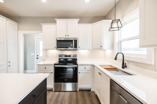 kitchen featuring pendant lighting, white cabinetry, sink, and appliances with stainless steel finishes