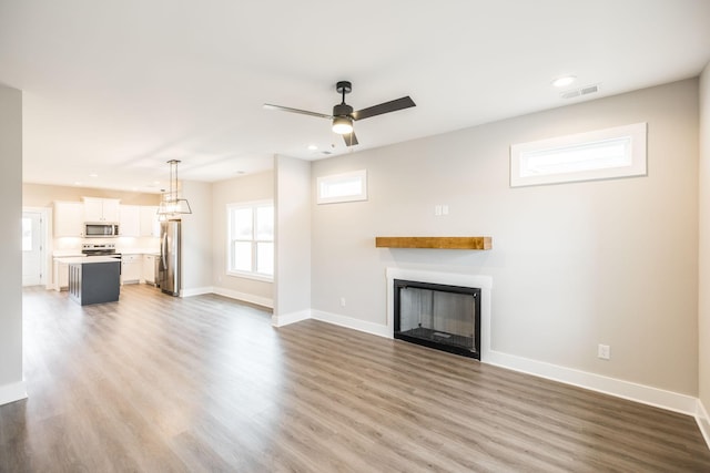 unfurnished living room with hardwood / wood-style floors and ceiling fan