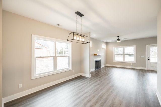 unfurnished living room featuring ceiling fan and hardwood / wood-style floors