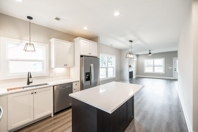 kitchen featuring white cabinets, a center island, sink, and stainless steel appliances