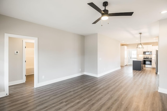 unfurnished living room featuring ceiling fan and dark wood-type flooring