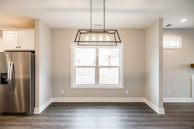 unfurnished dining area featuring dark wood-type flooring