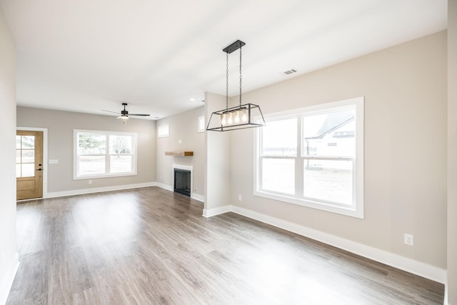 unfurnished living room with wood-type flooring and ceiling fan