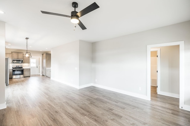 unfurnished living room with ceiling fan and wood-type flooring