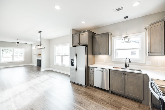 kitchen featuring pendant lighting, ceiling fan, sink, and stainless steel appliances