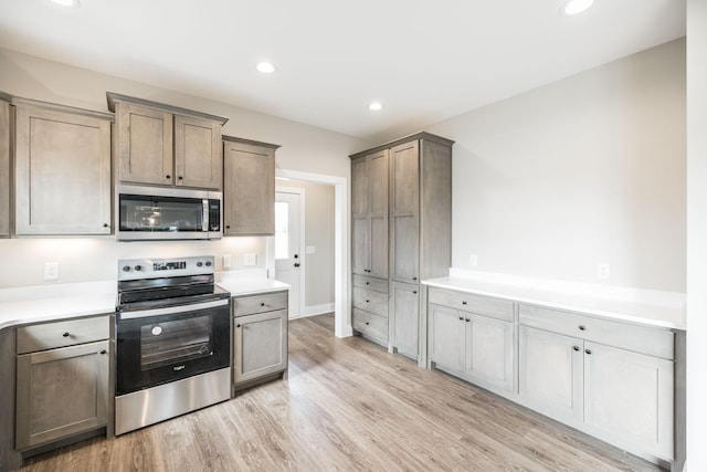 kitchen with light wood-type flooring and appliances with stainless steel finishes