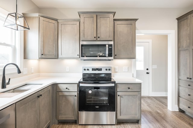 kitchen featuring decorative light fixtures, sink, plenty of natural light, and stainless steel appliances