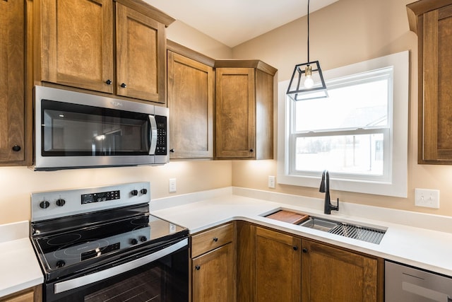 kitchen with pendant lighting, sink, and stainless steel appliances