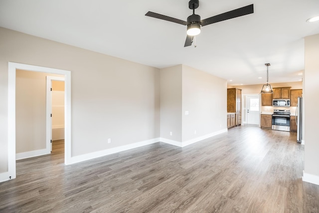 unfurnished living room with wood-type flooring and ceiling fan