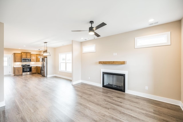 unfurnished living room featuring light hardwood / wood-style floors and ceiling fan