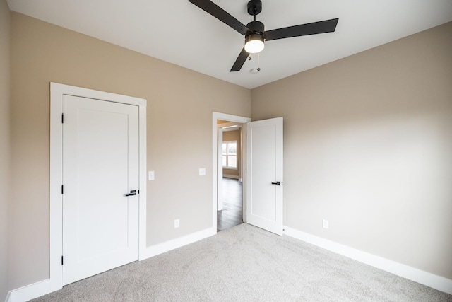 unfurnished bedroom featuring ceiling fan and light colored carpet