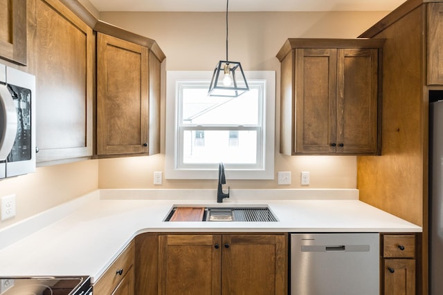 kitchen featuring sink, hanging light fixtures, and appliances with stainless steel finishes