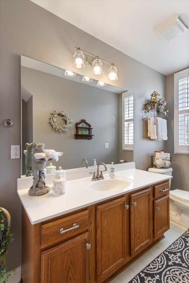 bathroom with tile patterned flooring, vanity, toilet, and plenty of natural light