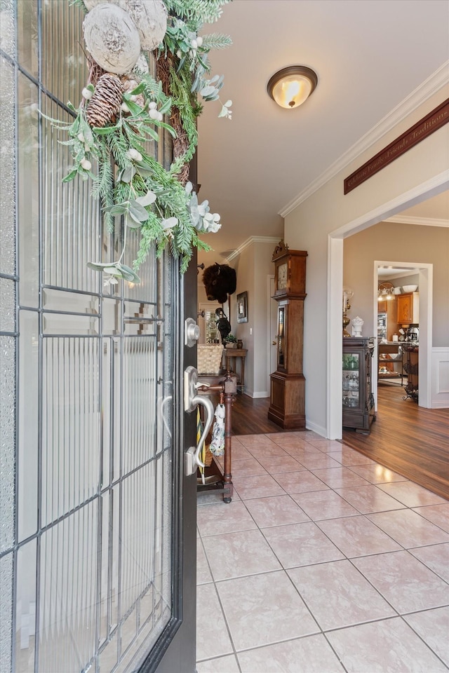 foyer entrance with tile patterned flooring and crown molding