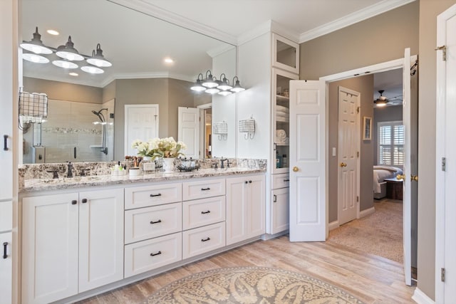 bathroom featuring wood-type flooring, vanity, an enclosed shower, and crown molding