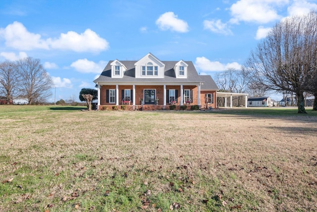 new england style home featuring a front lawn and covered porch