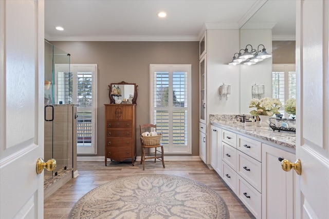 bathroom with vanity, wood-type flooring, and ornamental molding