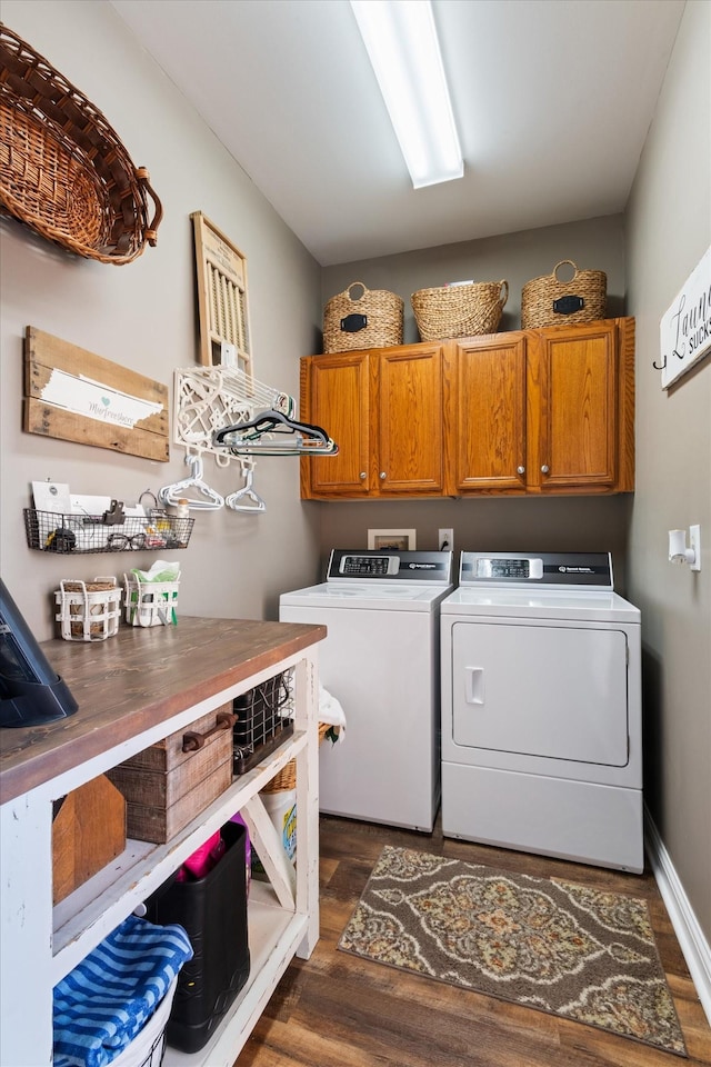 washroom featuring cabinets, separate washer and dryer, and dark hardwood / wood-style floors