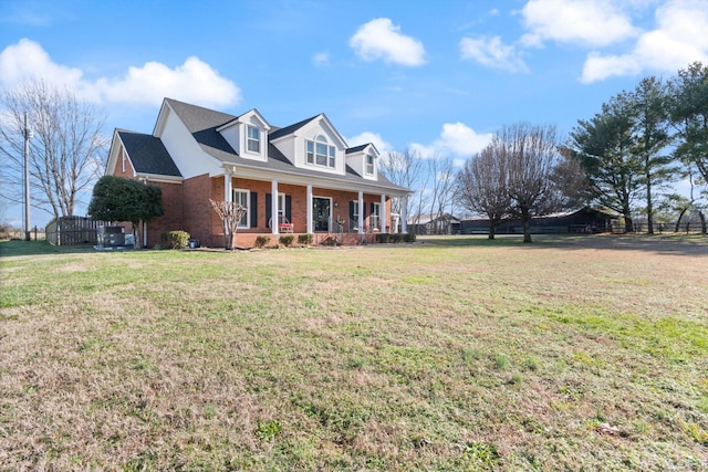 cape cod home with a porch and a front lawn