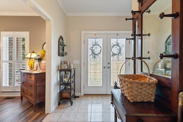 foyer entrance featuring french doors, light tile patterned floors, and crown molding