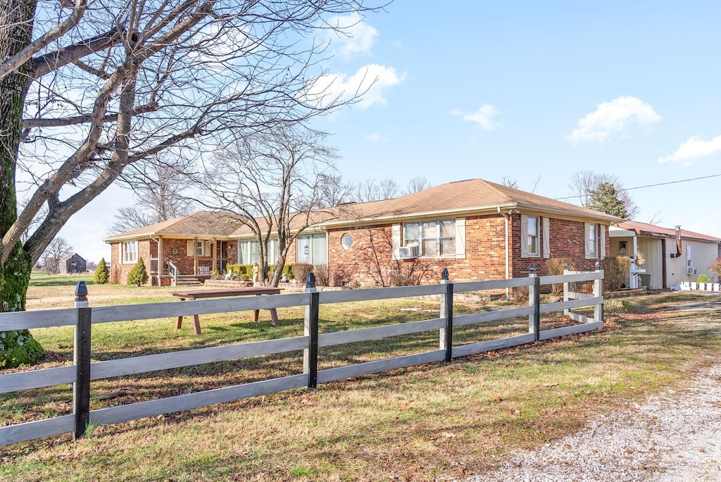 view of front of property featuring a front lawn and cooling unit