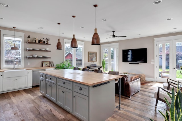 kitchen featuring wooden counters, french doors, sink, pendant lighting, and a kitchen island