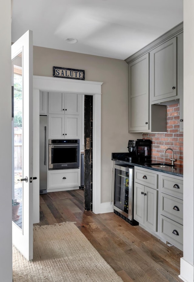 kitchen with gray cabinetry, sink, wine cooler, dark hardwood / wood-style floors, and stainless steel appliances