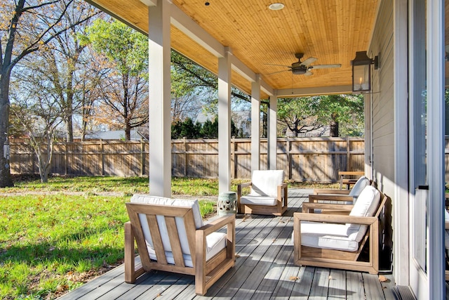 wooden deck with a lawn, ceiling fan, and outdoor lounge area