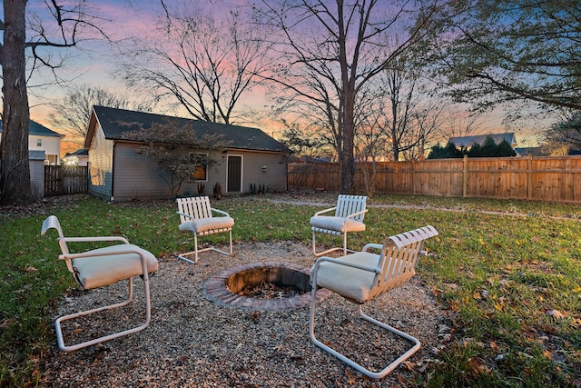 yard at dusk with an outbuilding and an outdoor fire pit