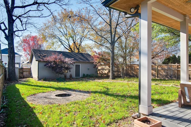 view of yard featuring an outdoor structure and an outdoor fire pit