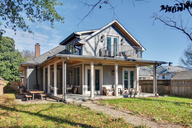 rear view of house featuring a yard, a patio, a balcony, and ceiling fan