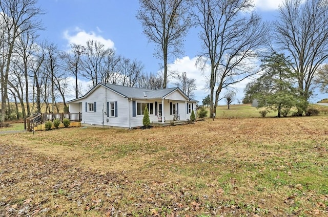 view of front of home with a front yard and a wooden deck