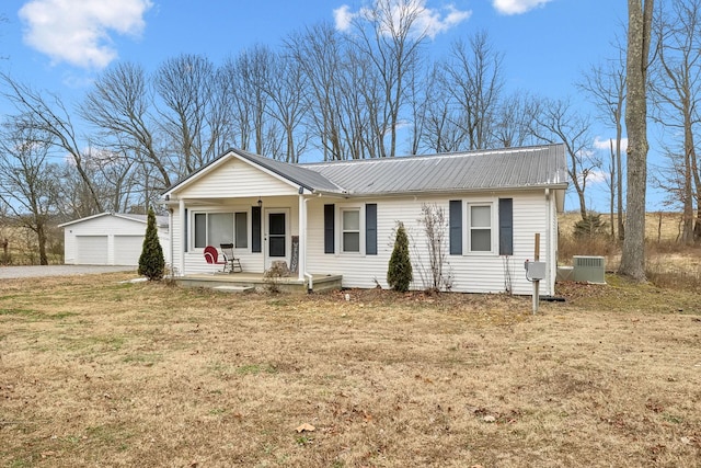 ranch-style house featuring an outbuilding, a front lawn, covered porch, and a garage