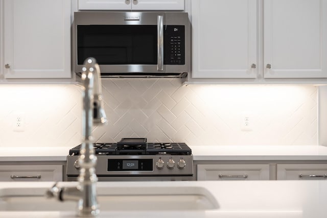 kitchen with tasteful backsplash, sink, and white cabinets