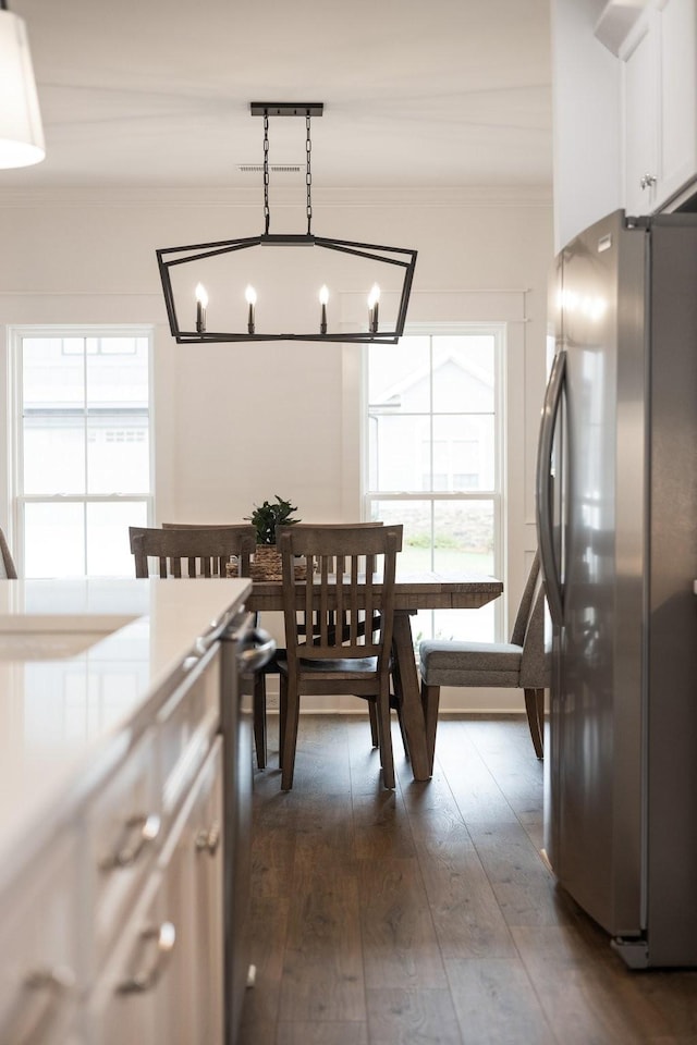 dining room with crown molding, dark wood-type flooring, and a notable chandelier