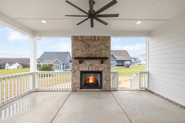 view of patio featuring an outdoor brick fireplace and ceiling fan